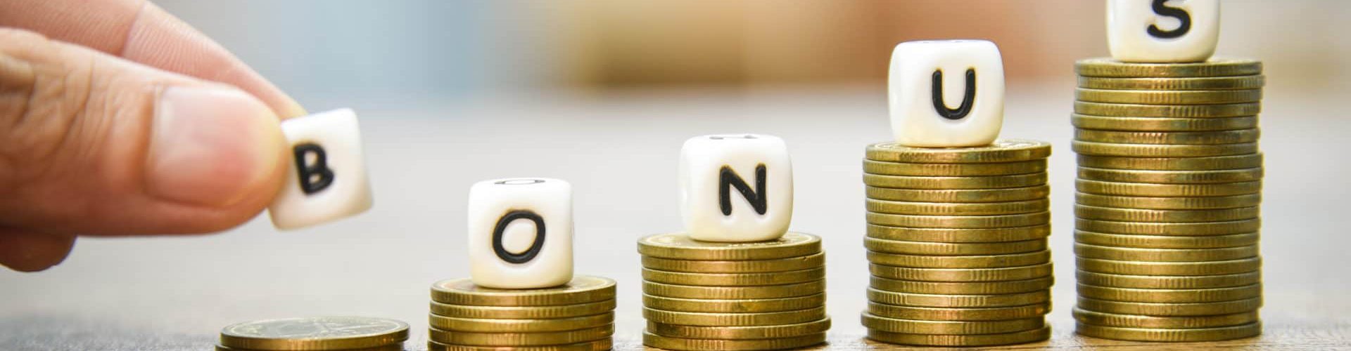 Yearly Bonus concept / hand holding words of bonus on stack coins staircase for Encouragement Morale on the table office company